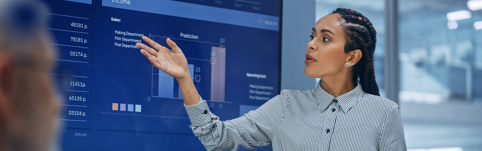 A woman stands in front of a screen, actively involved in Data Governance.